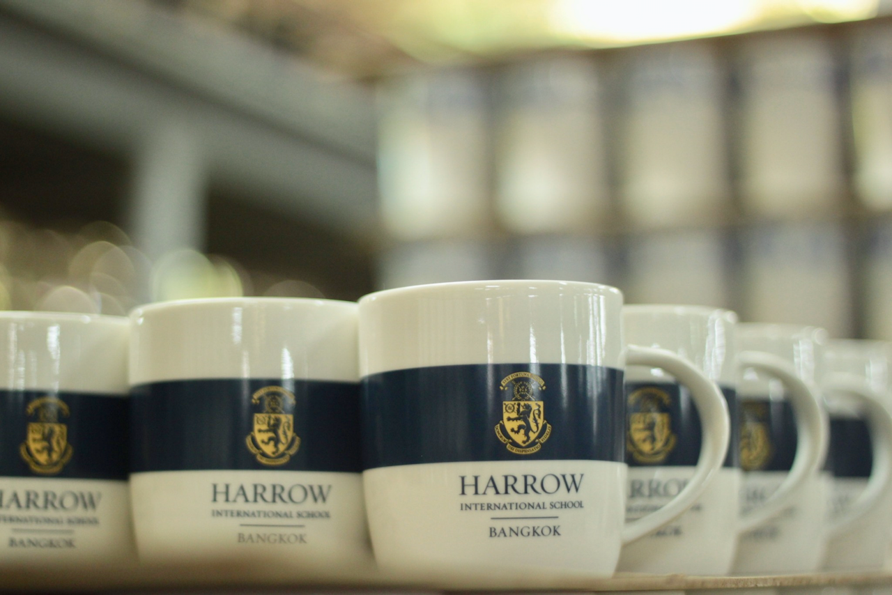 แก้วเซรามิคสกรีนตรา Harrow International School Bangkok ในขั้นตอนการผลิต